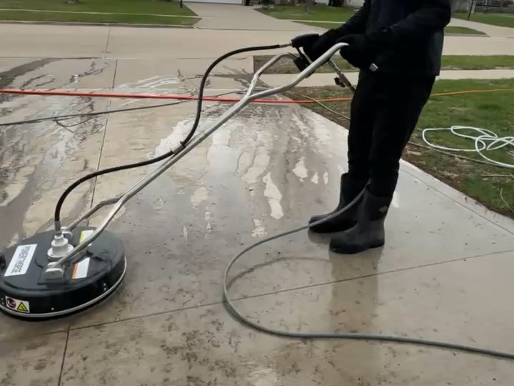 Power washing a concrete driveway